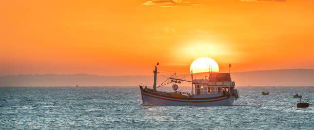 sea landscape at sunset when fishing boats out to sea to harvest fish end the day. - day to sunset imagens e fotografias de stock