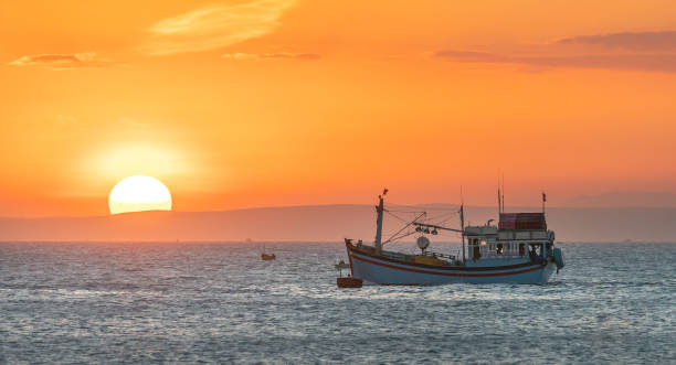 sea landscape at sunset when fishing boats out to sea to harvest fish end the day. - day to sunset imagens e fotografias de stock