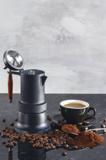 istock Coffee maker Type geyser and black colored coffee cup, with coffee beans and freshly ground coffee in a spoon 1175871643