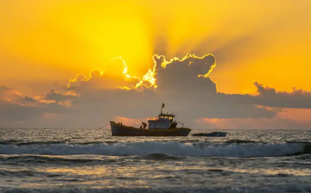 Fishing boats out to sea at dawn when the sun shines rays knob colorful welcome new day at sea
