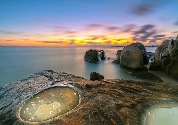 tramonto con acqua circolare piena di barriera corallina come l'occhio del drago - long exposure rock cloud sky foto e immagini stock