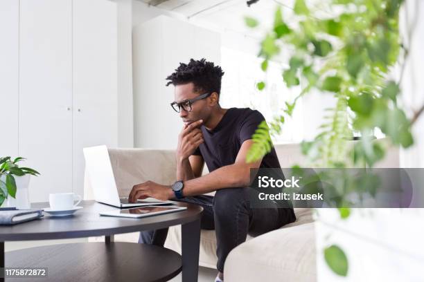 Confident Male Executive Working On Sofa In Office Stock Photo - Download Image Now - 30-34 Years, Adult, Adults Only