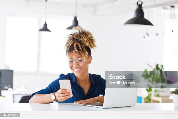 Smiling Female Hipster Executive Using Smart Phone Stock Photo - Download Image Now - Financial Advisor, 30-34 Years, Adult