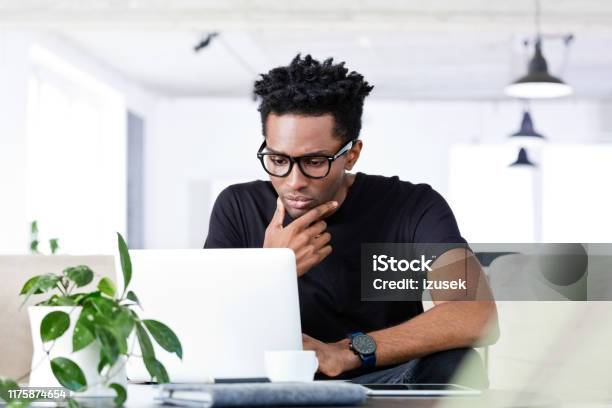Thoughtful Afro Businessman Using Laptop Stock Photo - Download Image Now - 30-34 Years, Adult, Adults Only