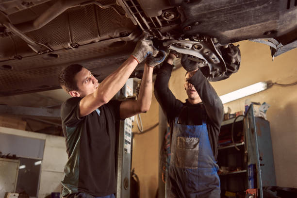istock Transmission checking and repairing. Two proficient auto mechanics working with lifted vehicle. Teamwork in car workshop 1175875228