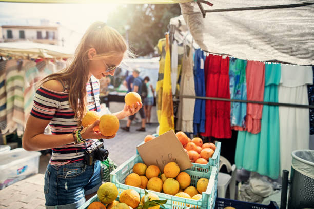 teenager-mädchen kaufen frische bio-orangen auf bauernmarkt - straßenmarkt stock-fotos und bilder