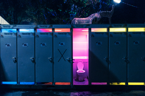 Bio toilet with opened door  on music festival with pink light in on music festival