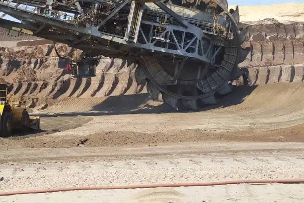 The work of a bucket wheel excavator in a quarry. Ore mining in a quarry.