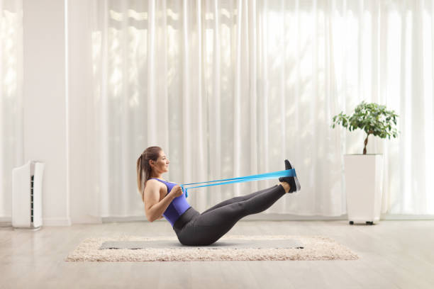 istock Young woman exercising with an elastic band on the floor 1175884087