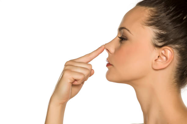 istock young woman touches her nose with her finger on a white background 1175887579