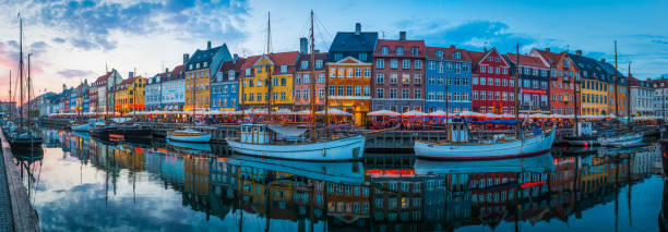 istock Copenhagen Nyhavn iconic harbour bars restaurants illuminated sunset panorama Denmark 1175888780