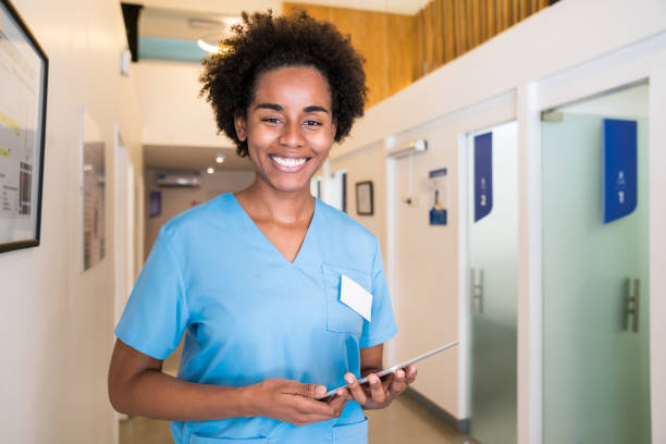 istock Smiling female nurse holding digital tablet 1175889523