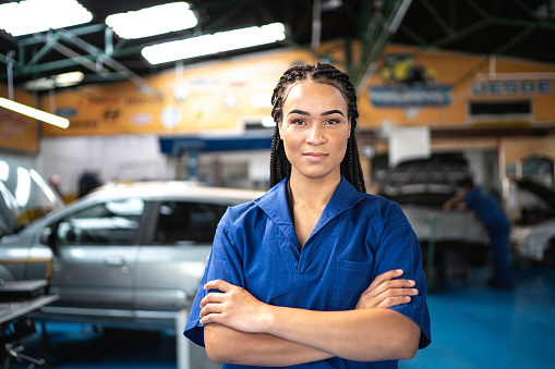 Portrait of a female mechanic with arms crossed in a auto repair shop