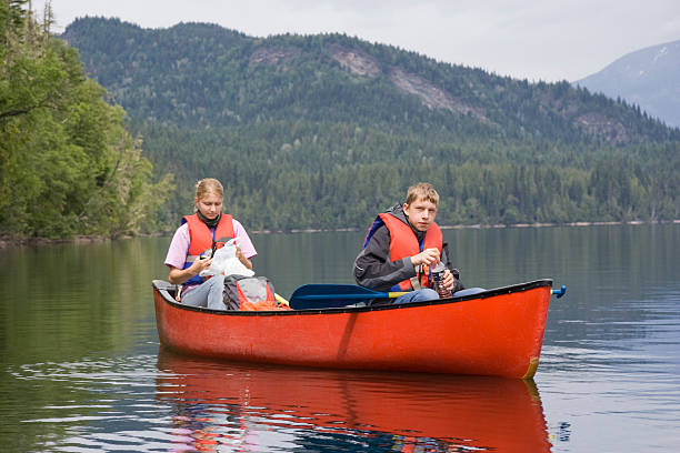 Happy mid adult couple looking away while canoeing in lake. Horizontal shot.