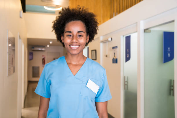 istock Smiling young female nurse standing in corridor 1175890488