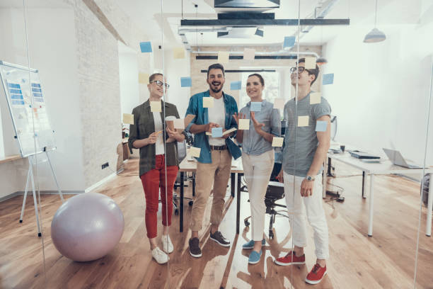 los socios felices están disfrutando de su trabajo juntos en la oficina - fundador fotografías e imágenes de stock