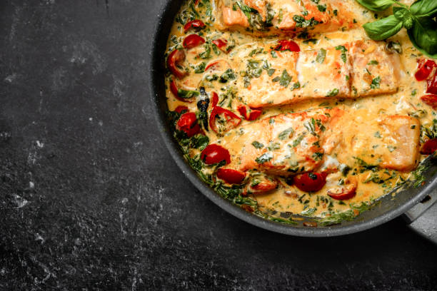 primer plano de delicioso salmón crema tuscan con espinacas en una sartén - baked salmon fotografías e imágenes de stock