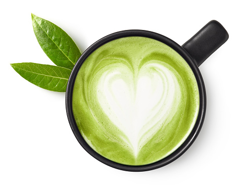 Cup of green tea matcha latte with heart shaped art isolated on white background, top view