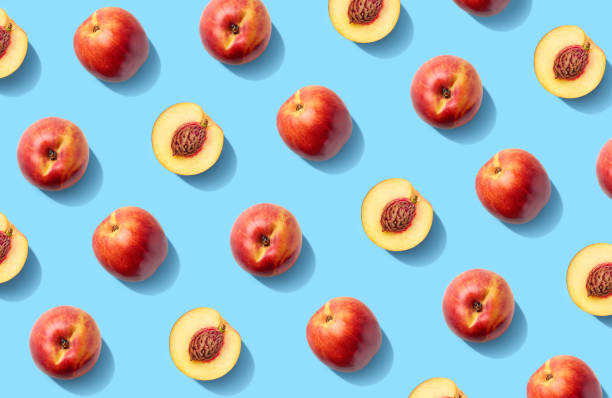 Colorful fruit pattern of fresh nectarines Colorful fruit pattern of fresh nectarines on  blue pastel background nectarine stock pictures, royalty-free photos & images