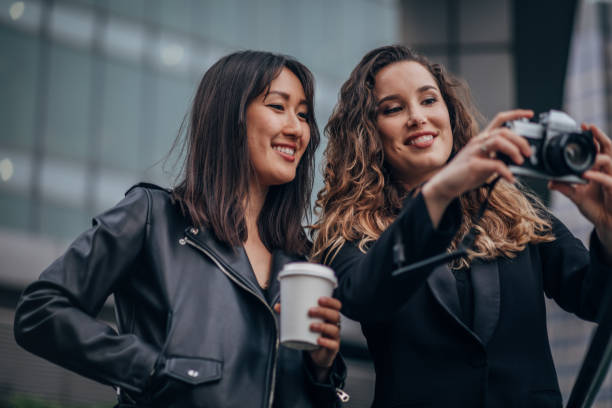 istock Beautiful ladies using camera on the street 1175895066