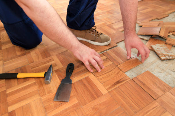 istock Construction worker and constructor is working on renovation of apartment. Handyman is removing old wooden parquet flooring using yellow hammer and scraping tool. Builder dismantles parquet floor. 1175896727