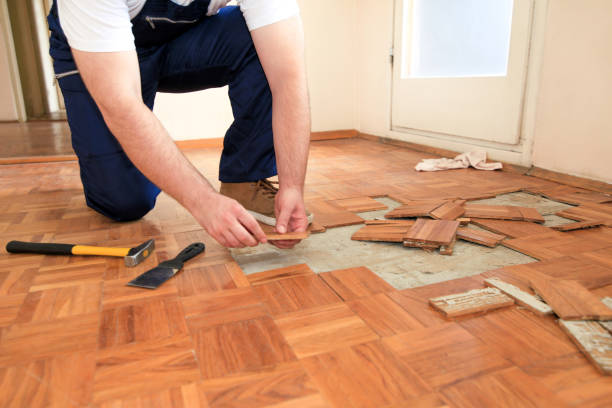 istock Construction worker and constructor is working on renovation of apartment. Handyman is removing old wooden parquet flooring using yellow hammer and scraping tool. Builder dismantles parquet floor. 1175896732