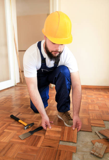 istock Construction worker and constructor is working on renovation of apartment. Handyman is removing old wooden parquet flooring using yellow hammer and scraping tool. Builder dismantles parquet floor. 1175896839