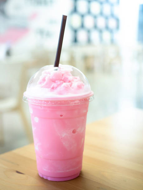 istock Cold milk smoothie in a plastic cup on a wooden table and has sunlight a beautiful background. 1175897221