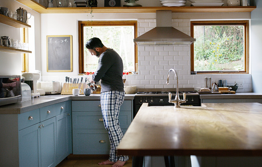 Shot of a man making two cups of coffee in the kitchen at home
