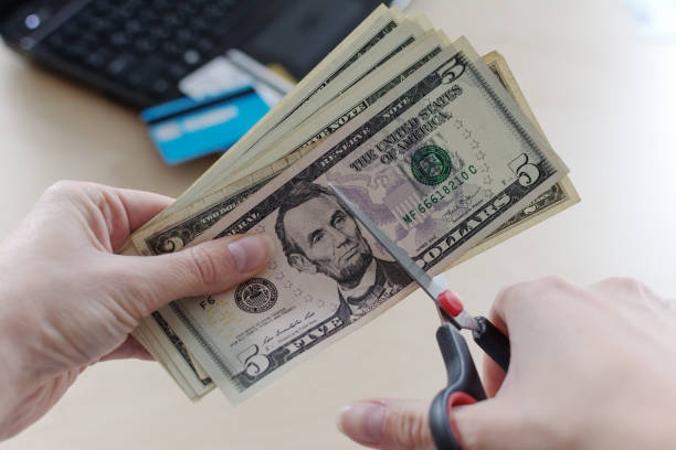 schneiden us-dollar-banknote mit einer schere. - home finances cutting scissors finance stock-fotos und bilder
