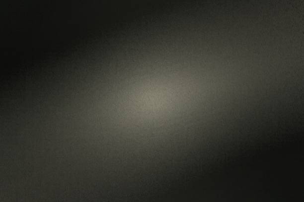 istock Black rough metal wall with light shining through in dark room, abstract background 1175904881