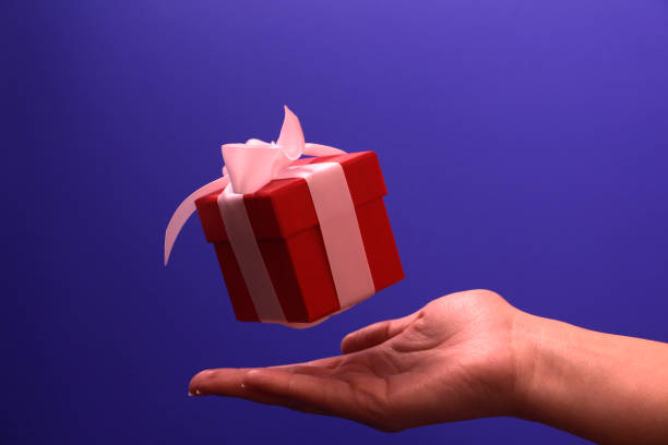 istock Beneath the gift is a female hand. Concept. Give a gift. 1175907443