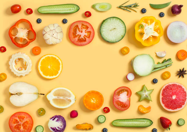 Colourful cross section vegetables and fruits on yellow background.