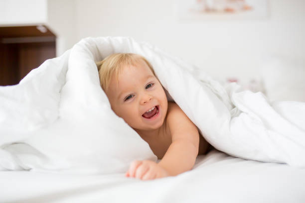 istock Cute little baby boy, relaxing in bed after bath, smiling happily 1175908656