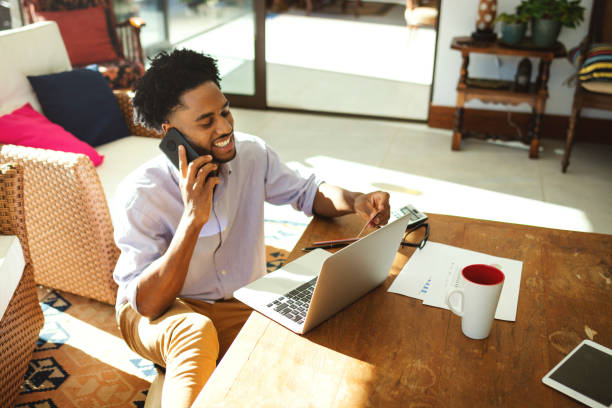 istock Young man using laptop and technology in the living room 1175908935