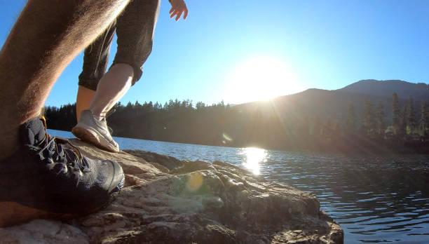istock Couple walk along lakeside rocks at sunrise 1175909952