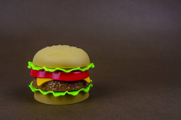 istock fast food. plastic hamburger on a brown background 1175910300