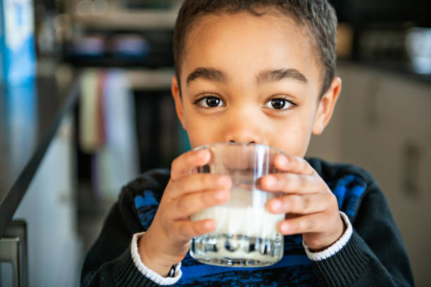 Cute African American boy drinking milk at home A Cute African American boy drinking milk at home dairy product photos stock pictures, royalty-free photos & images