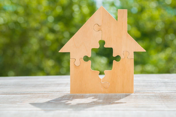 istock The wooden house is assembled from puzzle pieces. 1175911762