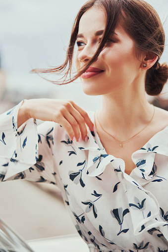 Close-up portrait of a young girl hipster beautiful brunette with red lips laughing and posing against the backdrop of the city