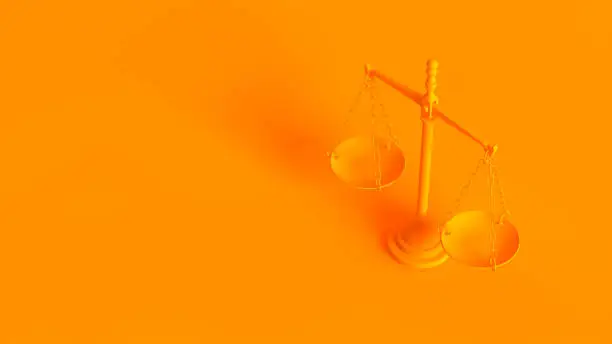 Photo of Conceptual image. Scales of justice isolated on orange background.