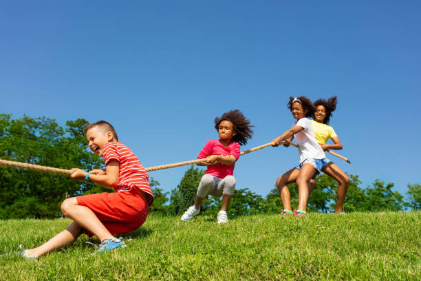istock Summer camp game of pulling cord in team on lawn 1175916480