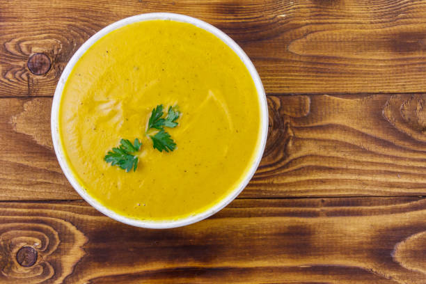istock Pumpkin soup on a wooden table. Top view 1175916640