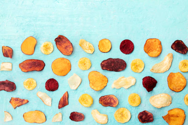 istock Dry fruit and vegetable chips, shot from the top on a blue background with a place for text. Healthy vegan snack, an organic food flat lay pattern with copy space 1175918302