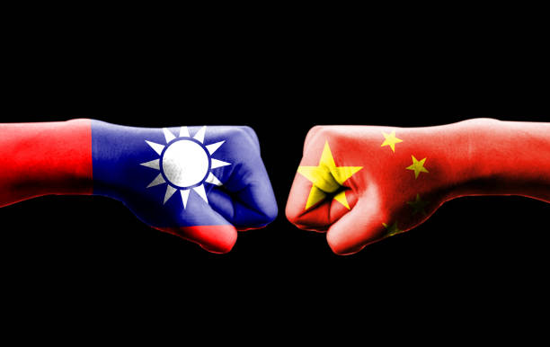 istock China and Taiwan flag print screen on hand with black background. Now both countries have economic and patriotic conflict. 1175920929