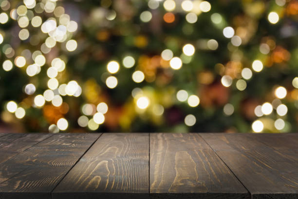 istock Wooden dark tabletop and blurred christmas tree bokeh. Xmas background for display your products. 1175921710