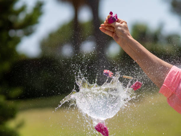 secuencia en varias fotos del lanzamiento de un dardo contra un globo lleno de agua y su posterior explosión. - rubber dart fotografías e imágenes de stock