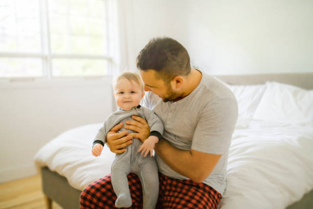 istock A Father with cute baby son on bed at home 1175925136