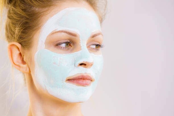 istock Girl with white green mud mask on face 1175925789