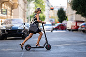 business woman on the move commuting to work with electric push scooter